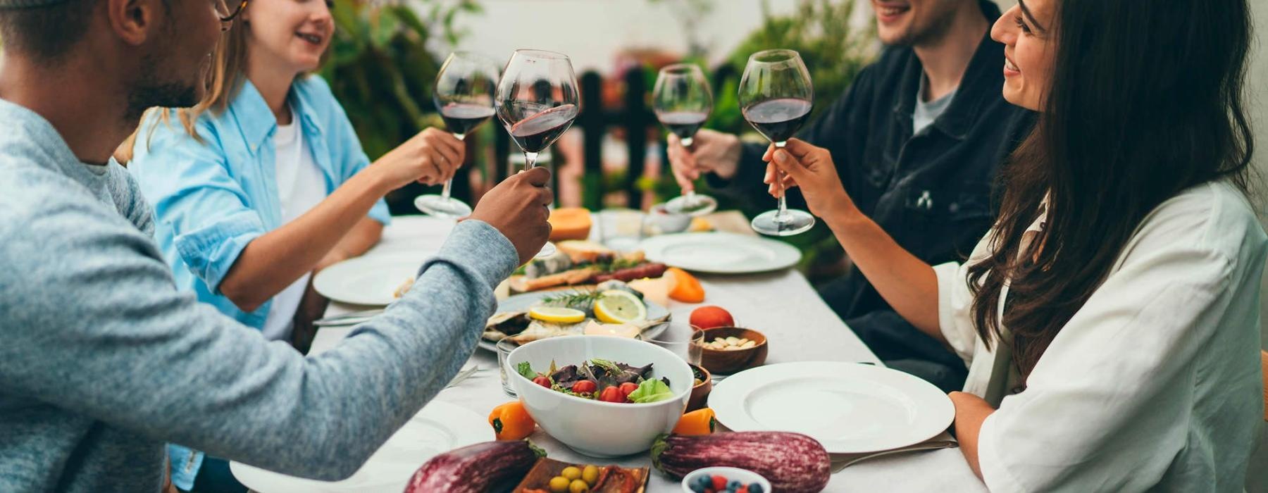 a group of people having a meal around an outdoor table