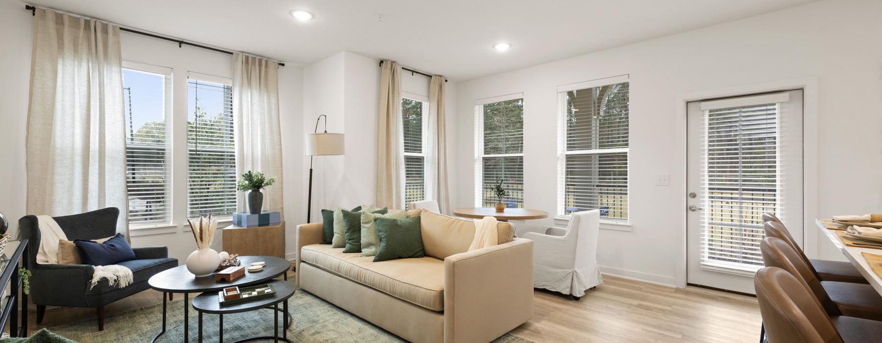 living room and dining area open to the kitchen with natural lighting